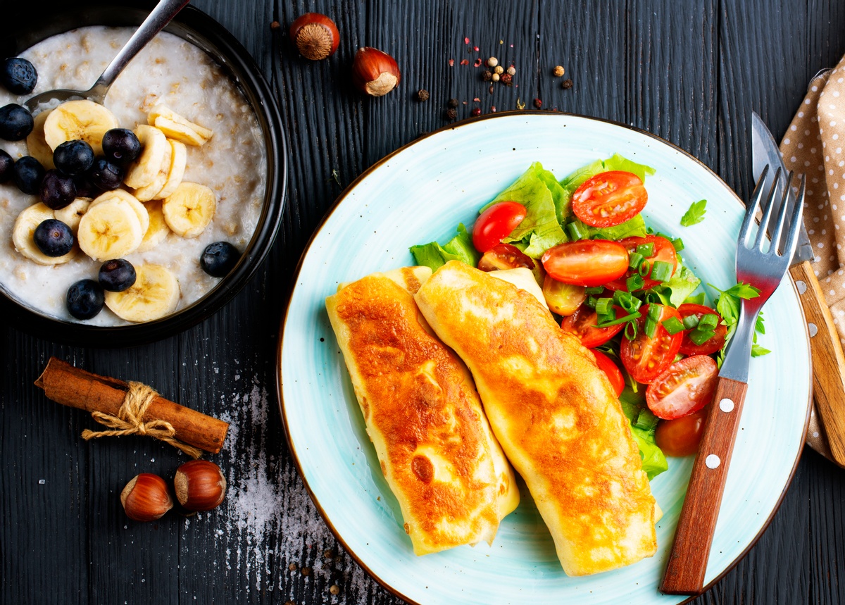 Ein Tisch mit Frühstück: Salat, Omelette und Müsli.