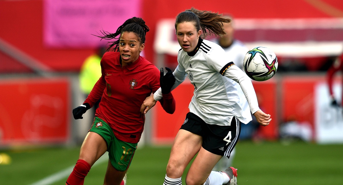 Eine deutsche Nationalspielerin im Kampf um den Ball mit einer portugiesischen Nationalspielerin.