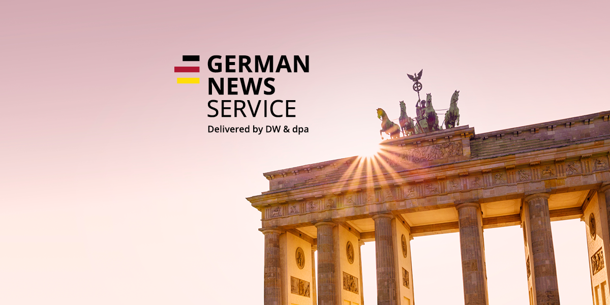 The picture shows the Brandenburg Gate in Berlin with the Quadriga sculpture backlit by the setting sun. Above it is the lettering "GERMAN NEWS SERVICE" and below it "Delivered by DW".